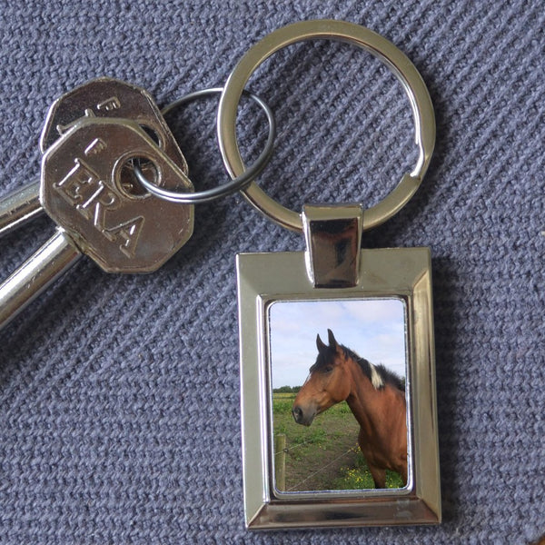 A personalised metal keyring in a rectangular shape featuring a personal photo 