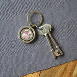 A personalised circular keyring with a spinning section. The keyring is personalised with a family photo.