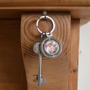 A personalised circular keyring with a spinning section. The keyring is personalised with a family photo.