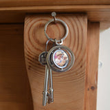 A personalised circular keyring with a spinning section. The keyring is personalised with a family photo.