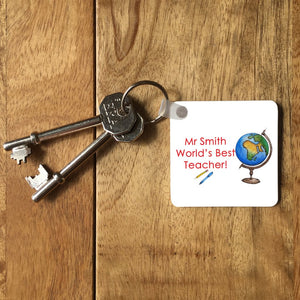 a personalised square key ring on a set of keys, the design on the key ring includes a globe and the message "Mr Smith, world's best teacher"